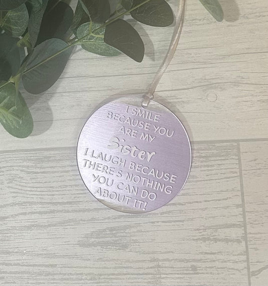 Circle acrylic hanging decoration with white wording 'I Smile Because You Are My Sister I Laugh Because There's Noting You Can Do About It!' with pearlescent lilac acrylic paint and satin ribbon